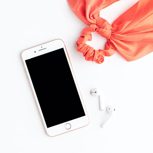 Cell phone with Airpods and a kids' toy