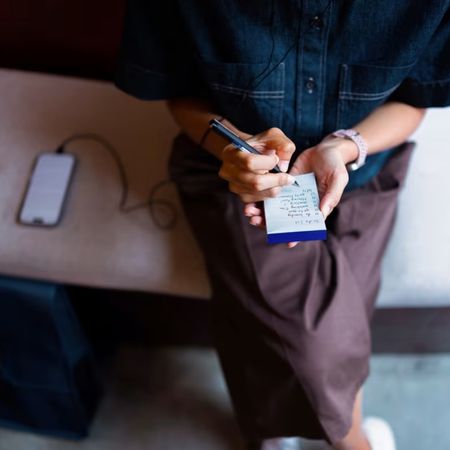 Woman with a list and a phone sitting
